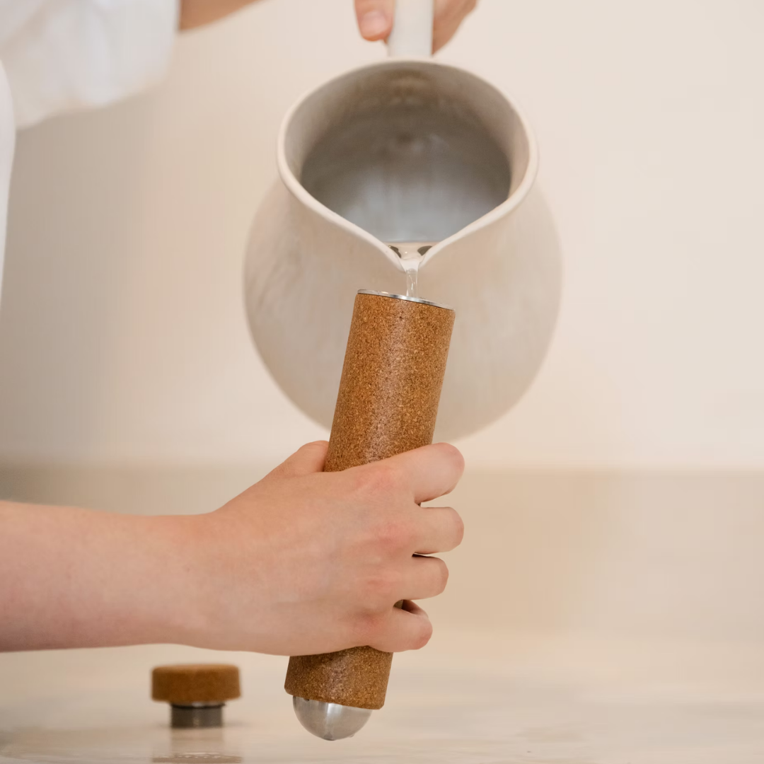 Person pouring hot water in the massage stick.