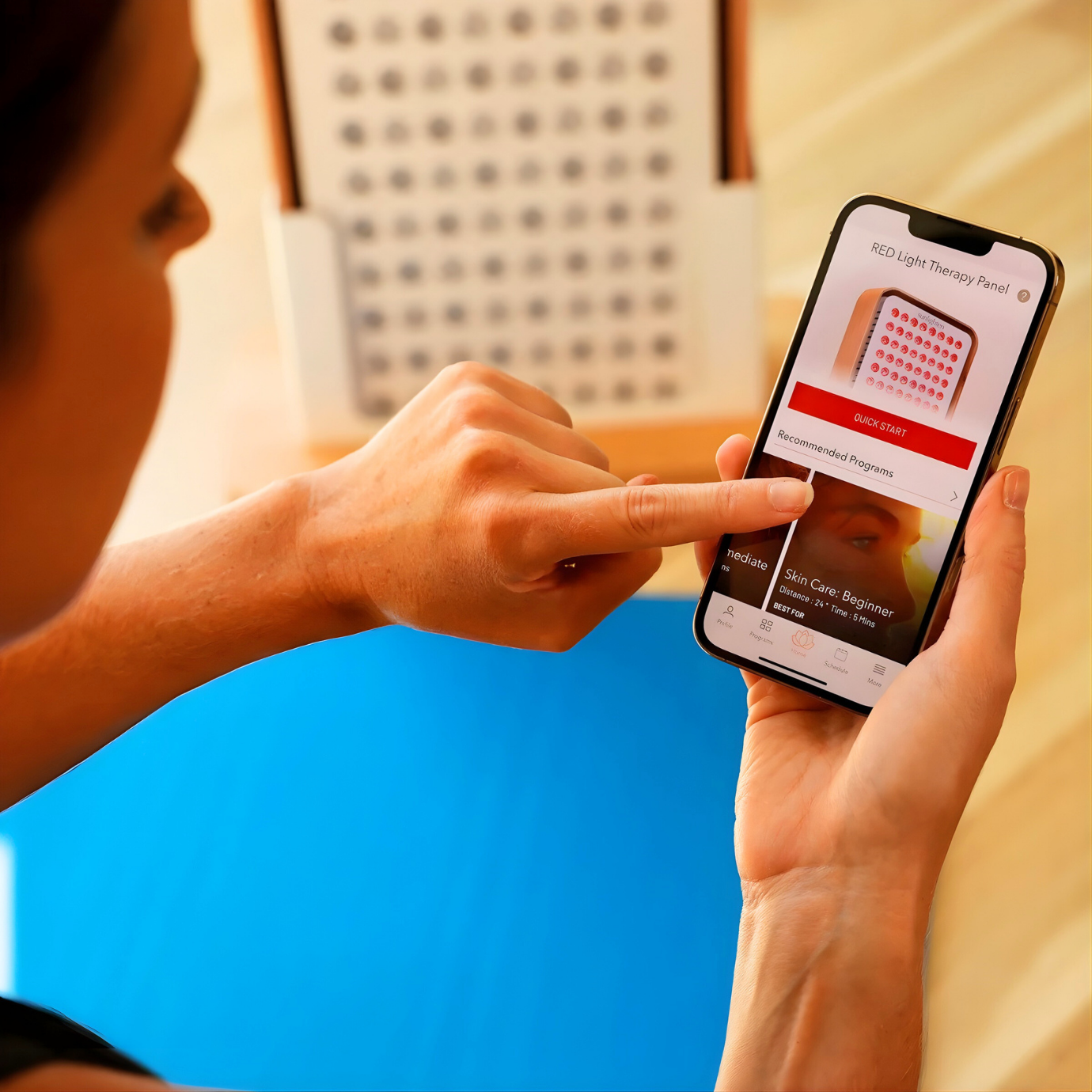 App-connected Sunlighten panel with light programs visible on phone screen.