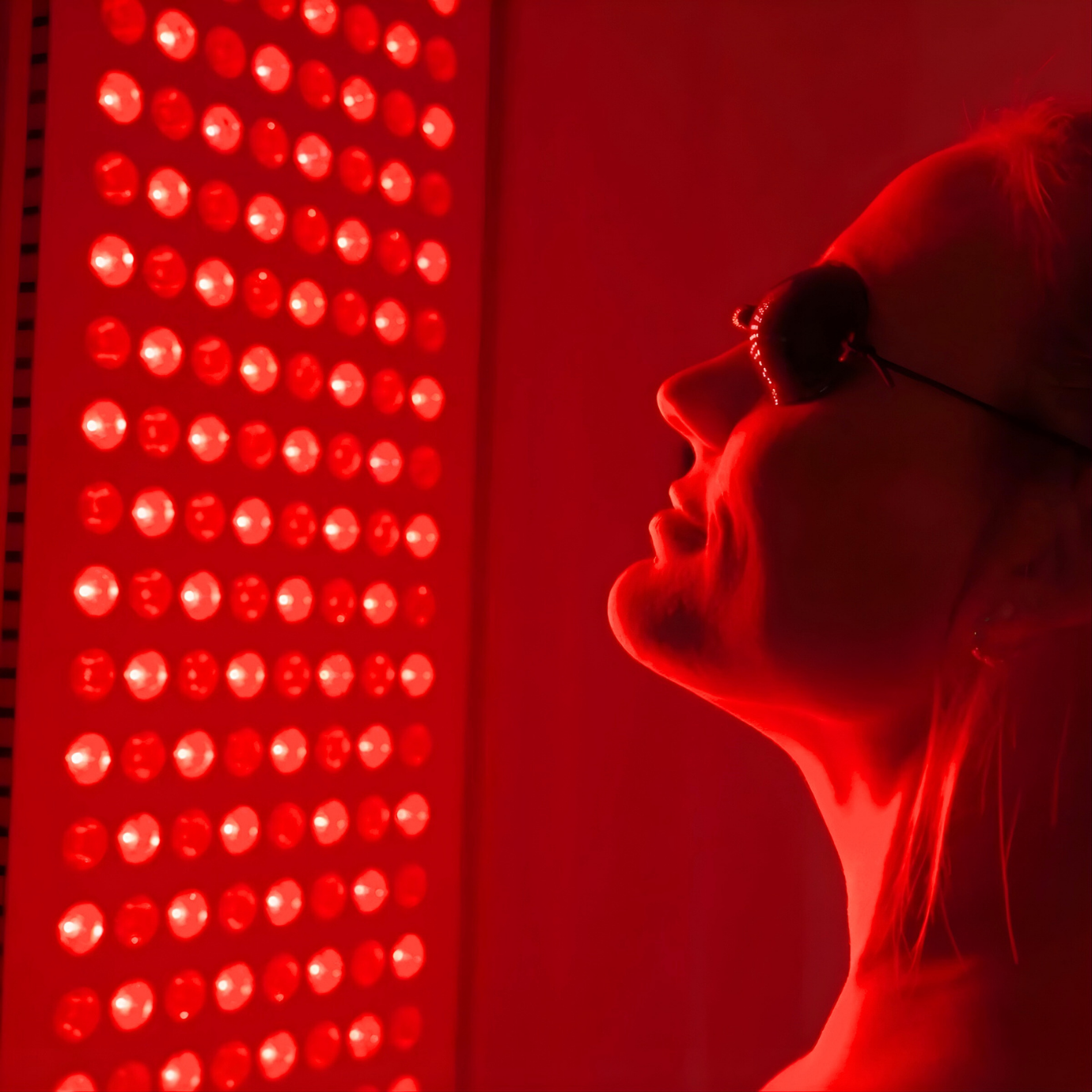 Person using Sunlighten Red Light Therapy Panel during a recovery session.