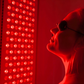 Person using Sunlighten Red Light Therapy Panel during a recovery session.