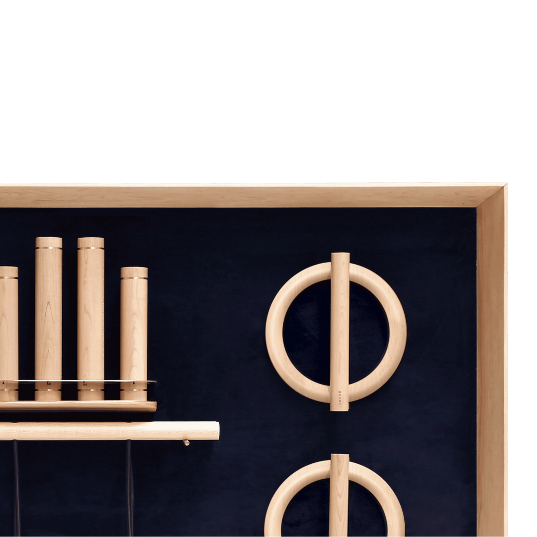 Push-up bars with cork handles arranged on minimalist wooden wall rack.