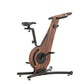 Close up view of a modern exercise bike with a walnut wooden frame and minimalist design, featuring an adjustable seat and streamlined structure. NOHRD Bike V2